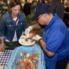 Diane Badasci watches as Rotarian Jesus Garcia serves up a dish of fresh crab.